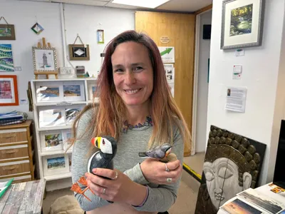 Holding a puffin and a small bird